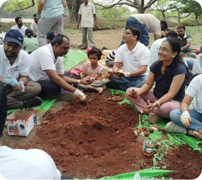 Group of participants making seedballs together in outdoor environment